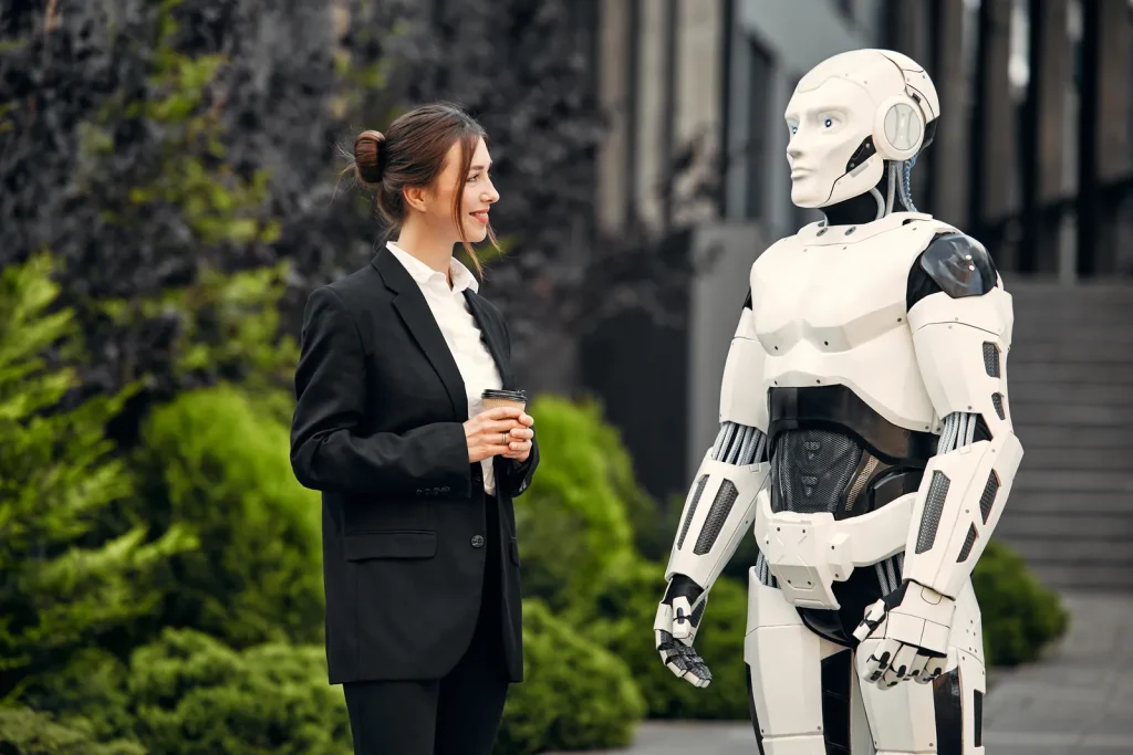 Profesional con un café conversa con un robot humanoide junto a un edificio de oficinas